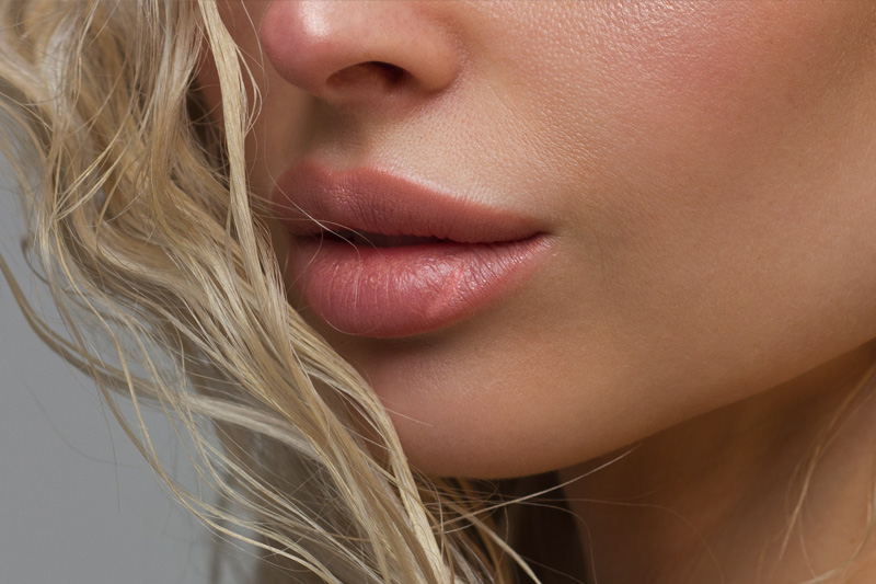 Close-up of woman's Lips with Fashion pink Make-up and Manicure on Nails. Beautiful female full lips with perfect Makeup. Part of female face. Macro shot of beautiful make up on full lips