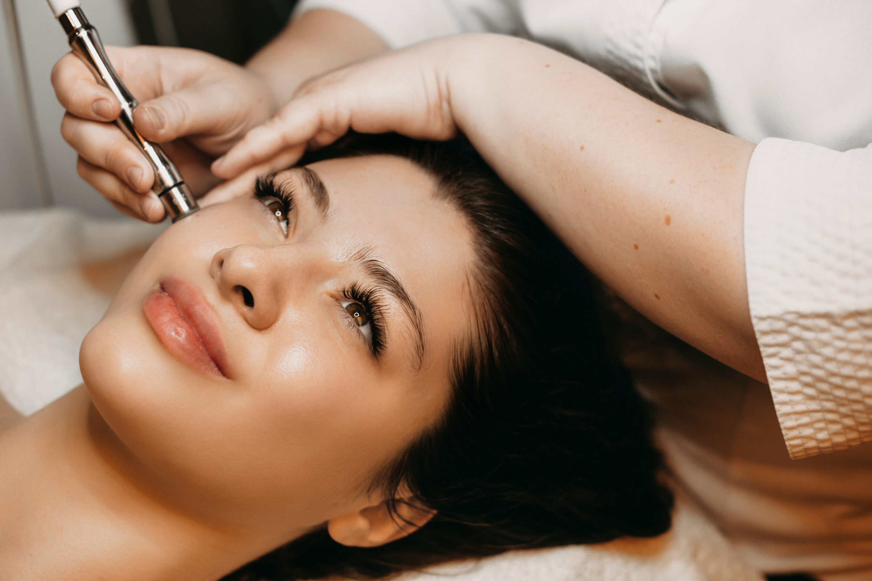 Side view portrait of a cute woman doing micro needling.